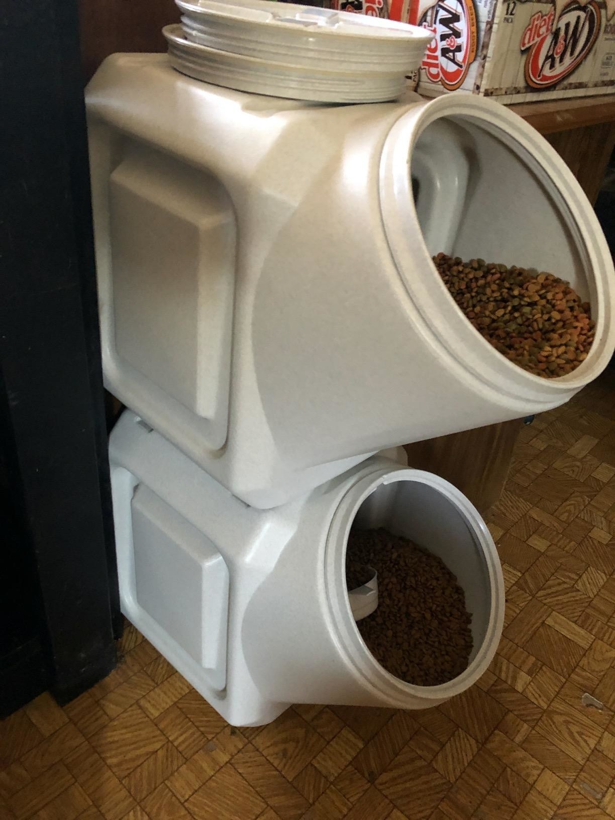 Two open storage containers stacked on top of one another with pet food inside