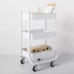 A white 3 tier cart on wheels filled with craft supplies