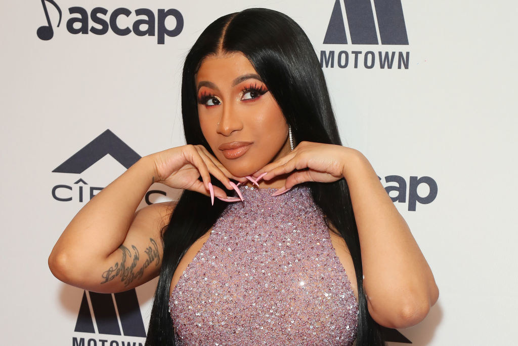 Cardi B looking up with her hands under her chin