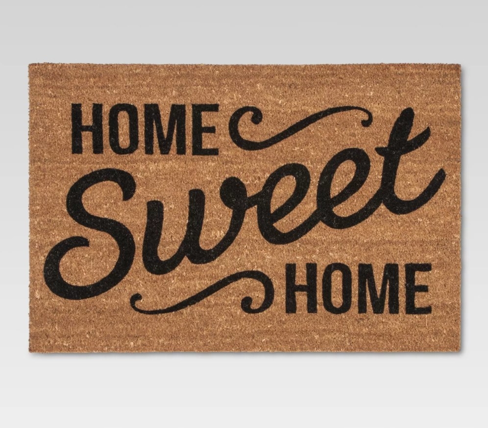 A brown doormat that says "Home Sweet Home" in black letters