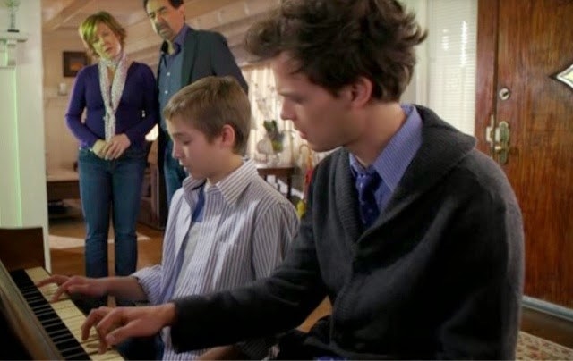 Spencer playing piano with a victim&#x27;s child. 