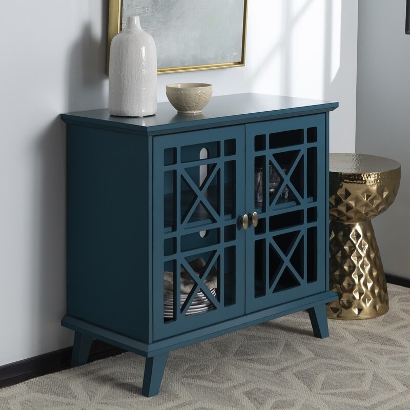 A blue accent cabinet with decorative doors