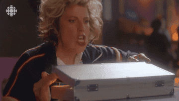Baroness von Sketch Show character reacts in ecstasy as she opens box.