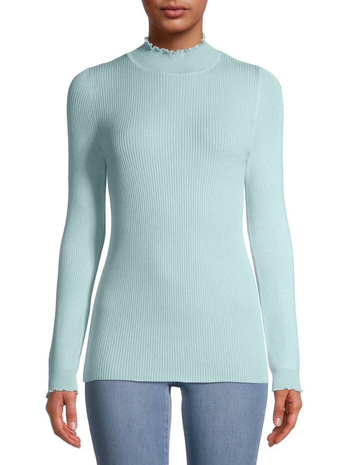 Model wearing light blue sweater with ruffled neckline