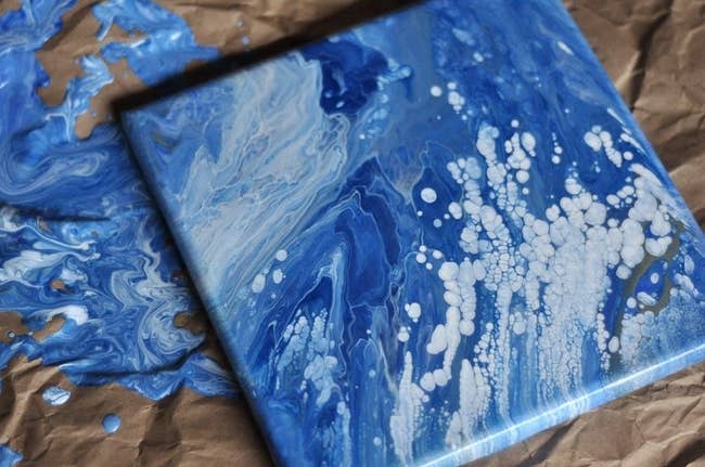 Blue and white drip painting on square canvas 