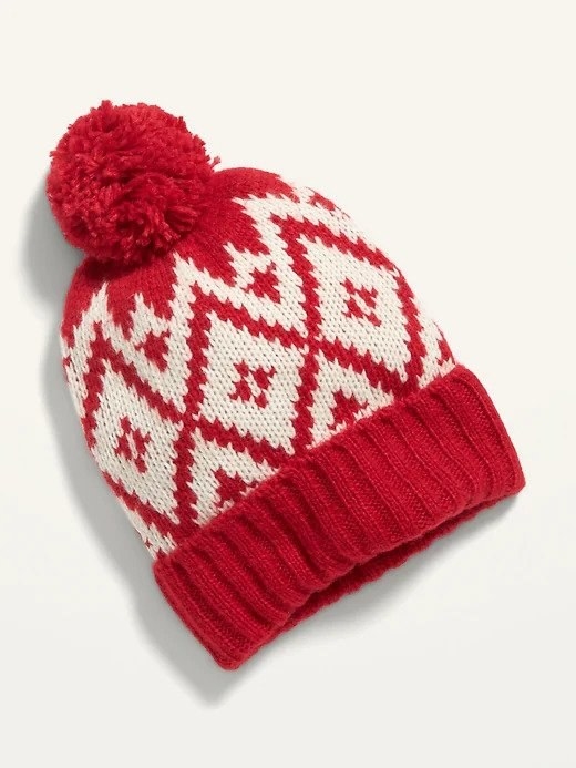 A red and white hat with a fuzzy ball at the top