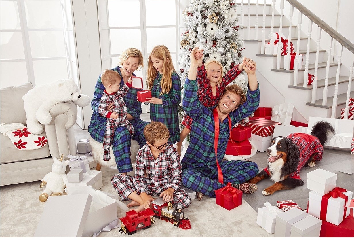 Kids and adults in matching plaid pajamas in blue and white and red 