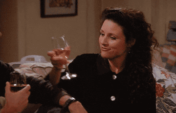 Elaine from Seinfeld angrily toasting with a glass of rosé