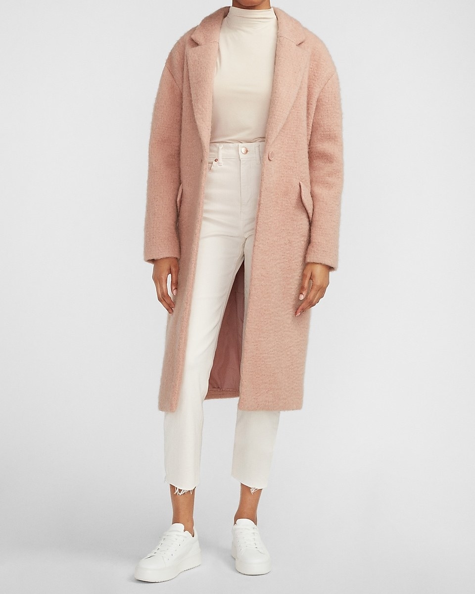 a model in the long coat in blush pink