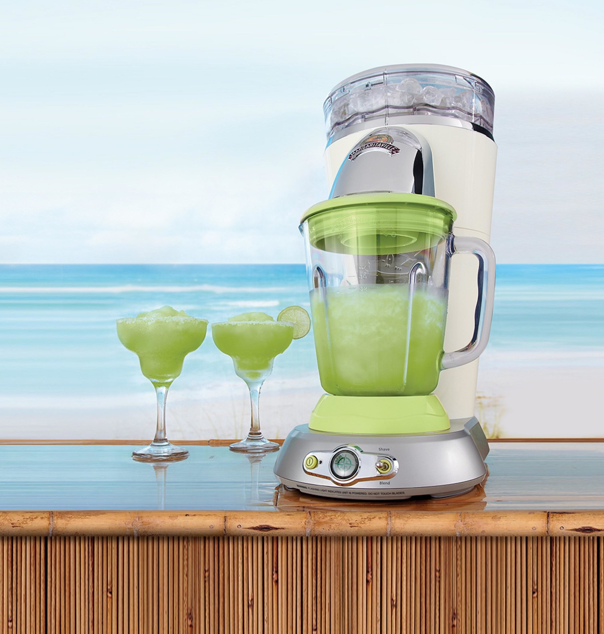 margaritaville frozen drink maker with a margarita in it and two margarita glasses on the bar