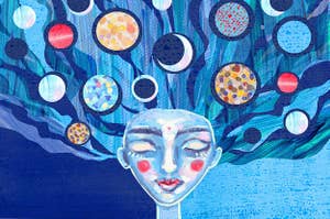 A painting of a blue woman with planets and moons in her hair 