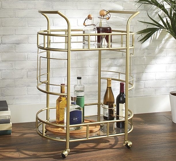 gold better homes & gardens bar cart with bottles on the bottom and top