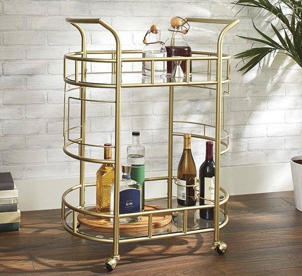 gold better homes &amp;amp; gardens bar cart with bottles on the bottom and top