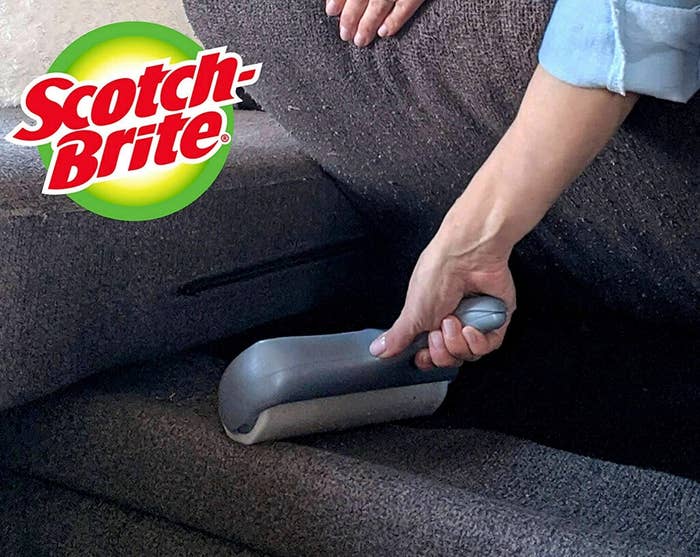 a model using the handheld roller under their couch cushion