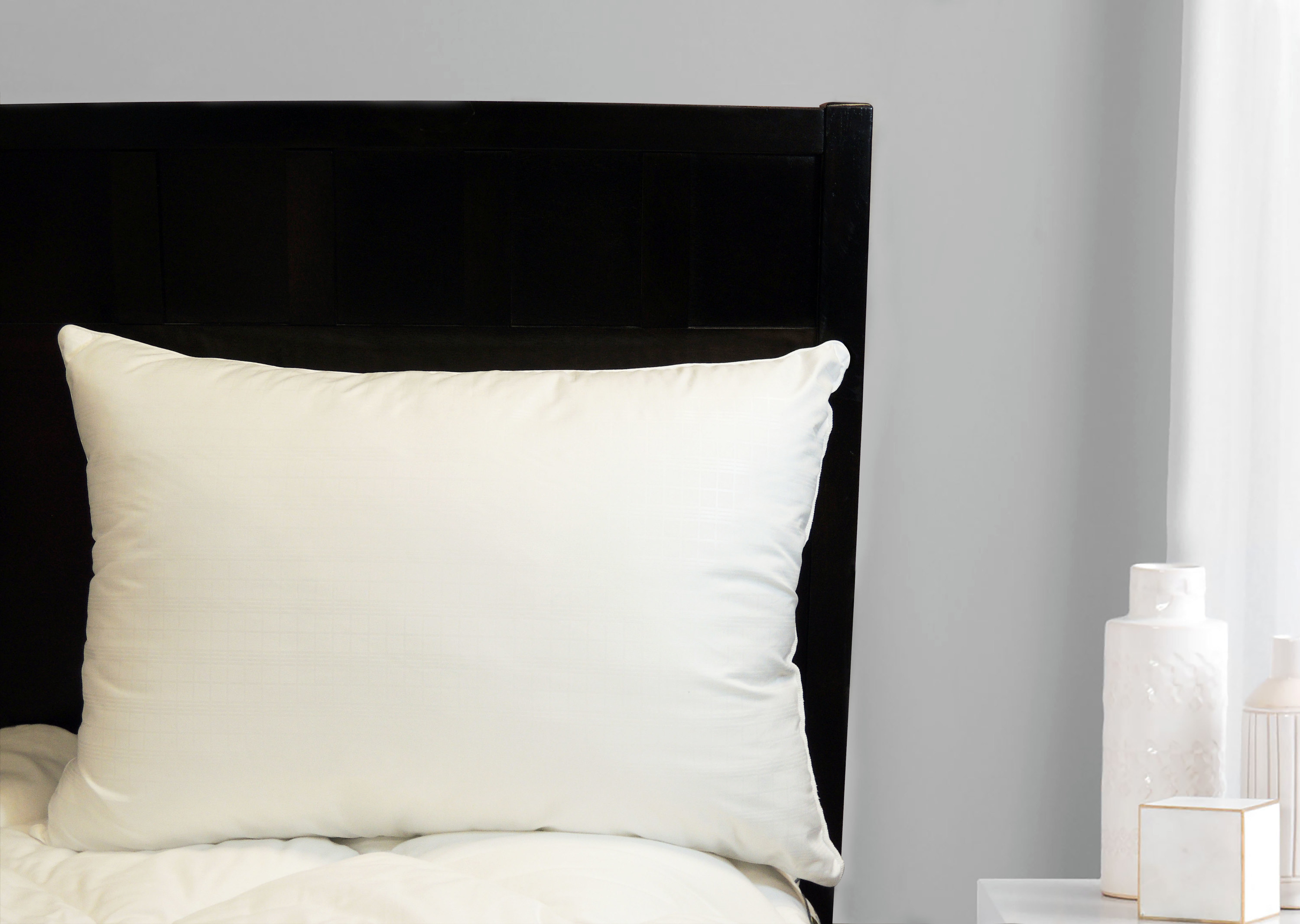 The pillow on a bed with a dark headboard