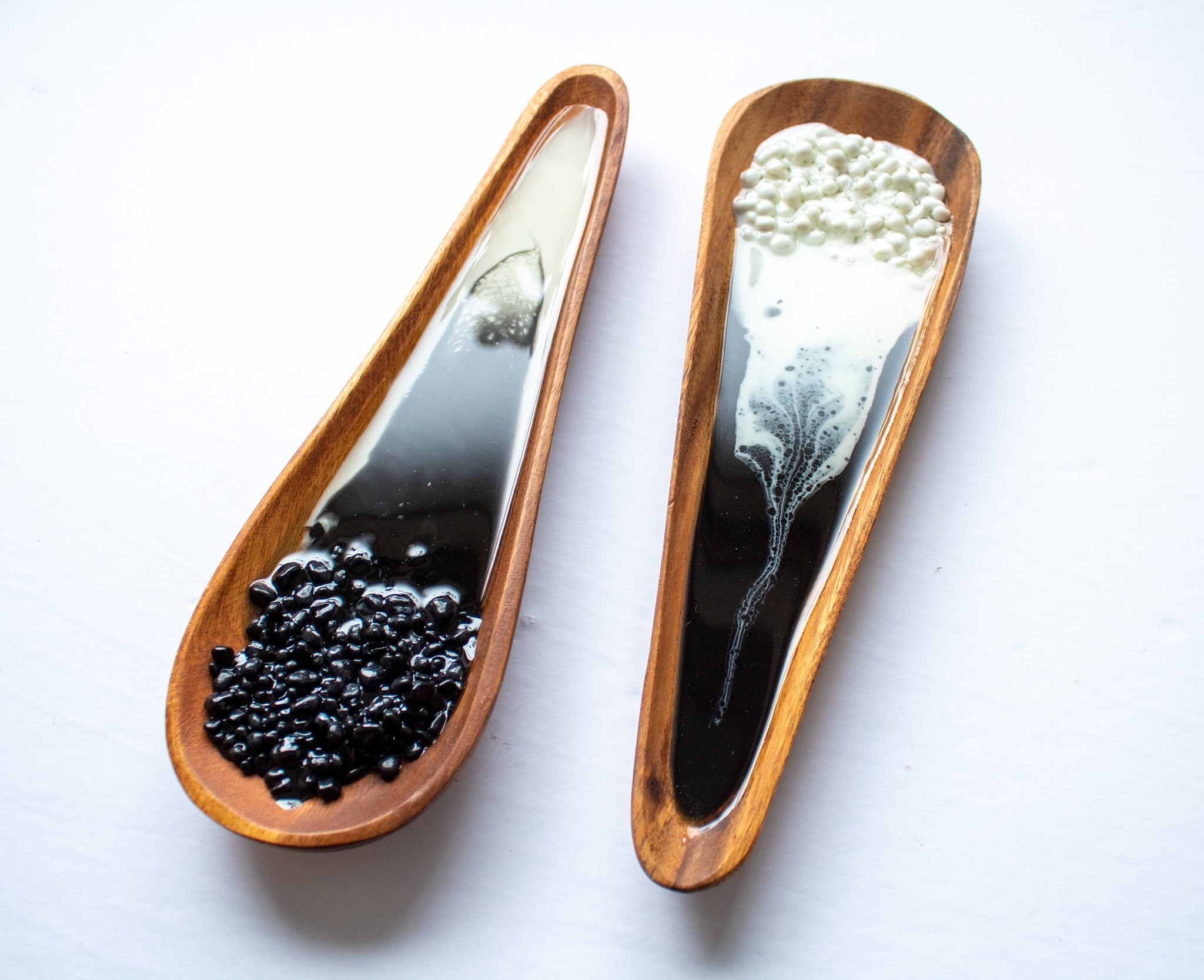 The wood spoon rest, which is round a wider on one side and smaller on the other,  and black and white resin in the inside