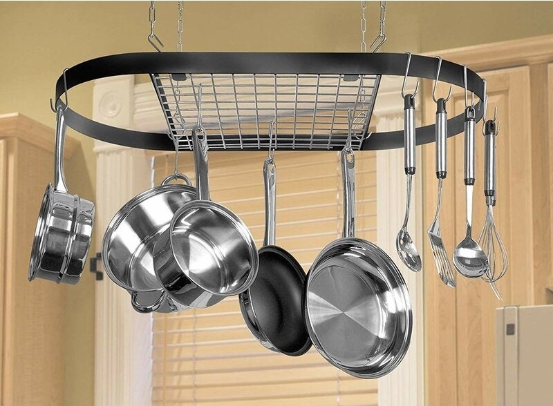 Black wrought iron pot rack with silver pots and pans hanging