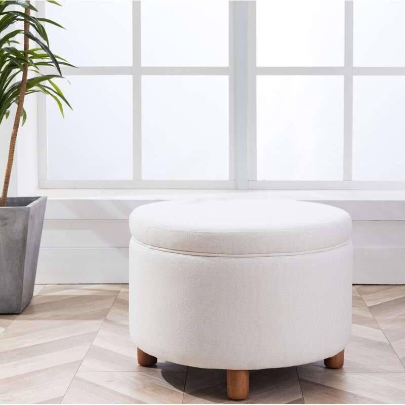 Cream round ottoman with brown legs