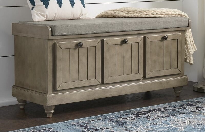 Antique gray storage bench with gray cushion and dark gray knobs