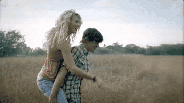 Taylor gets a piggyback ride in a field from a boy