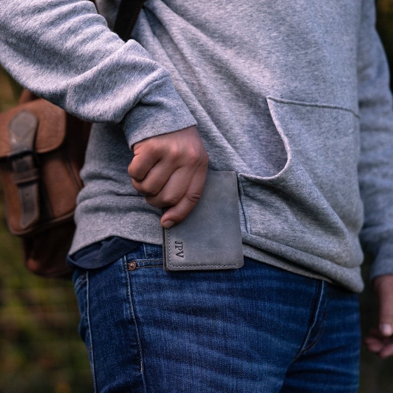 Person placing personalized wallet in pants pocket