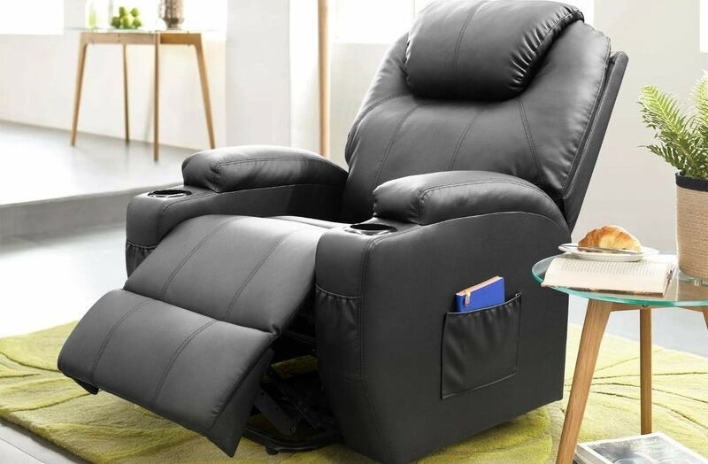 Black faux leather massage chair with blue book in its pocket