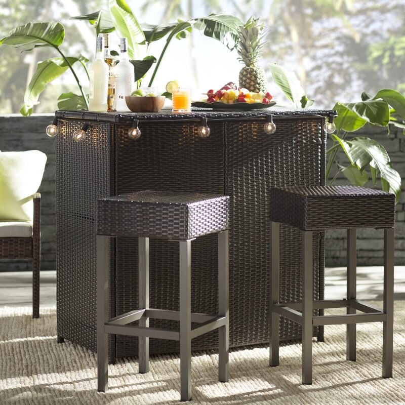 Dark brown wicker resin bar set with barstools that have gray legs