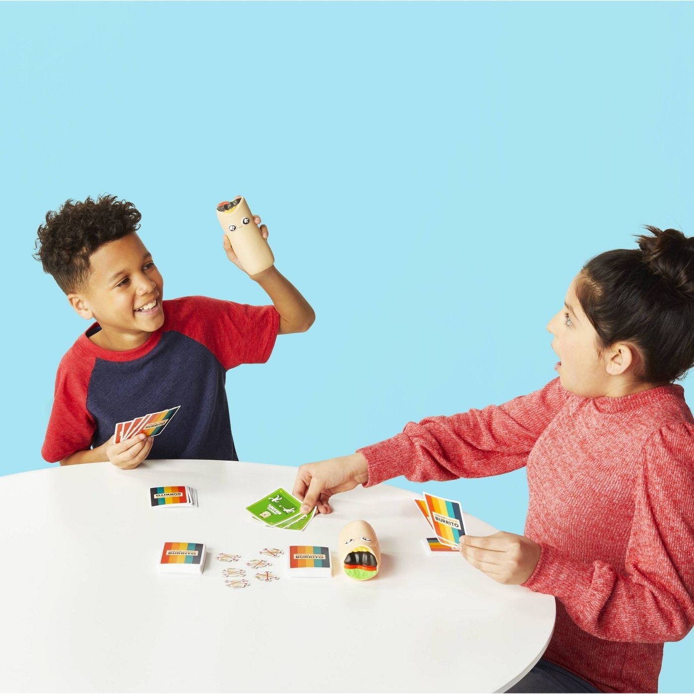 Children throwing a burrito plush toy while using the deck of cards