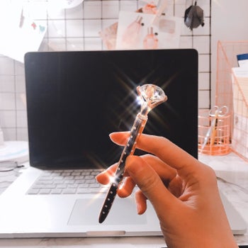 A reviewer's hand holding one of the the pens, which is sparkling