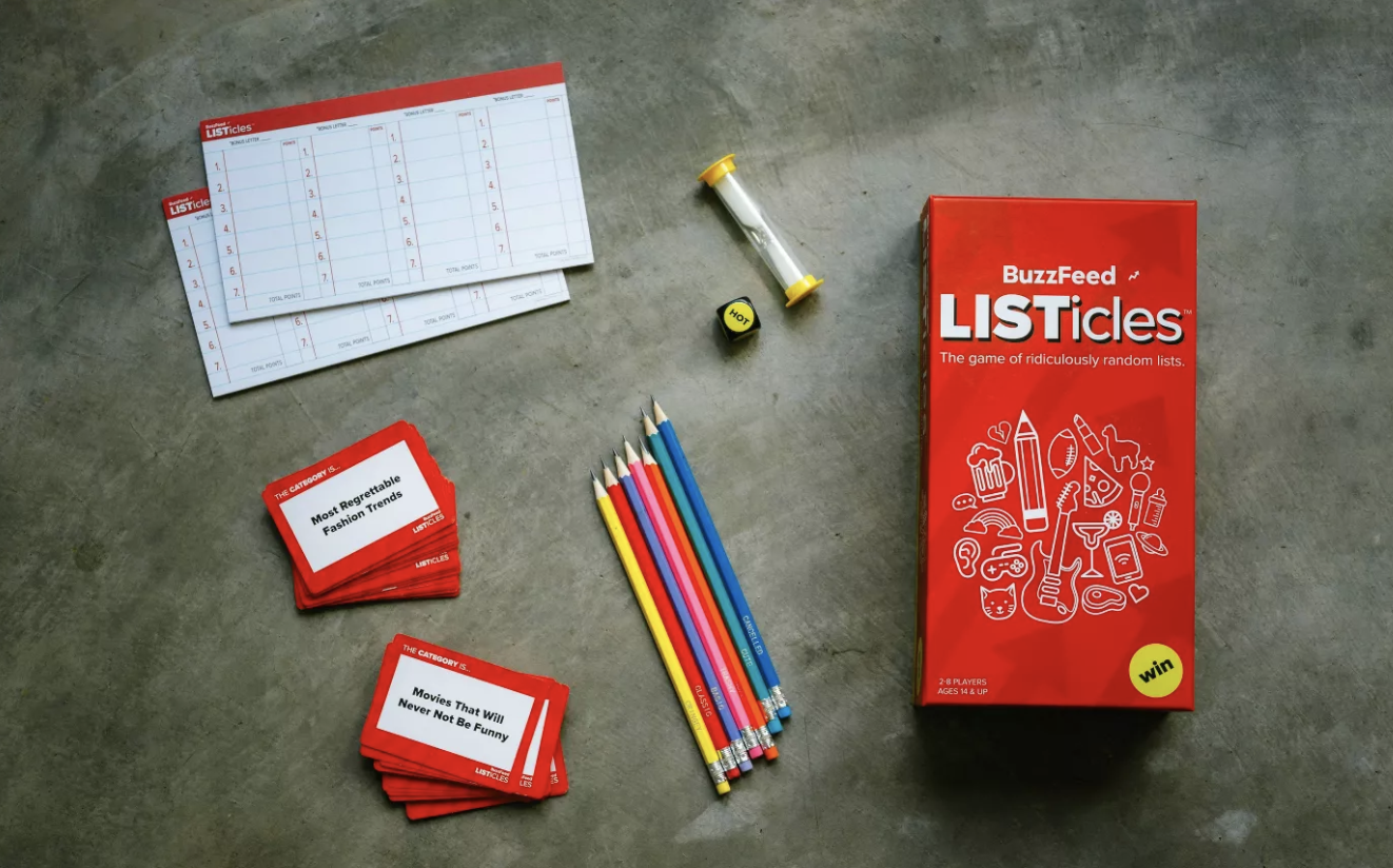 The game box, cards, pencils, timer, die, and pads for making lists