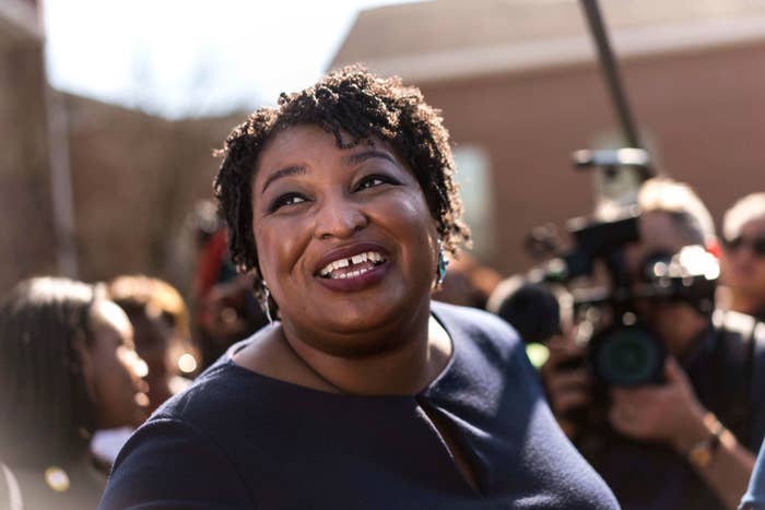 Stacey Abrams standing in a crowd of people as a camera is pointed at her
