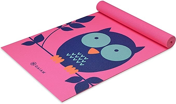 A pink kid-sized yoga mat with an owl design