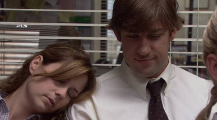 Jim smiles as Pam rests her head on his shoulder, sleeping