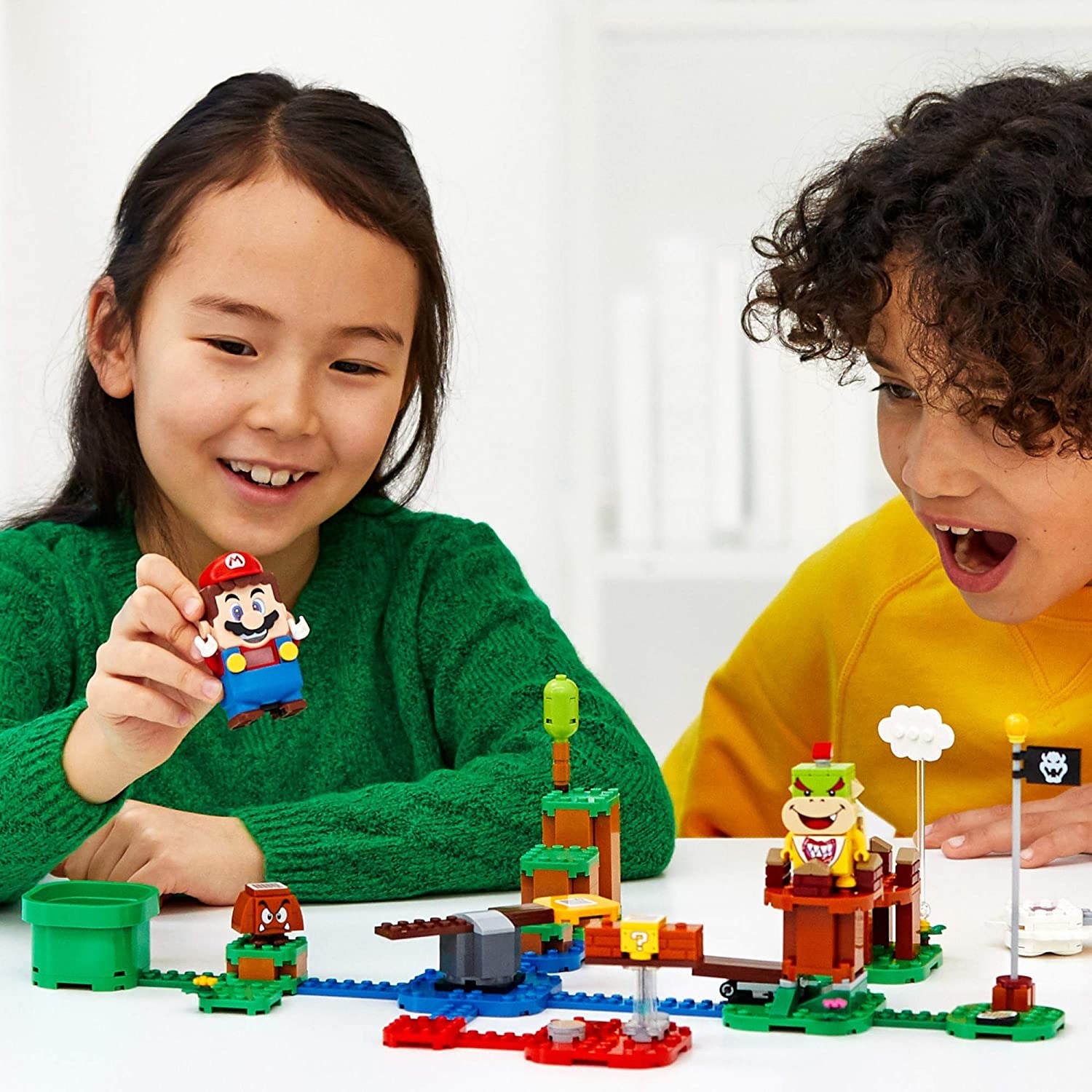 Two children playing with the Super Mario Lego set