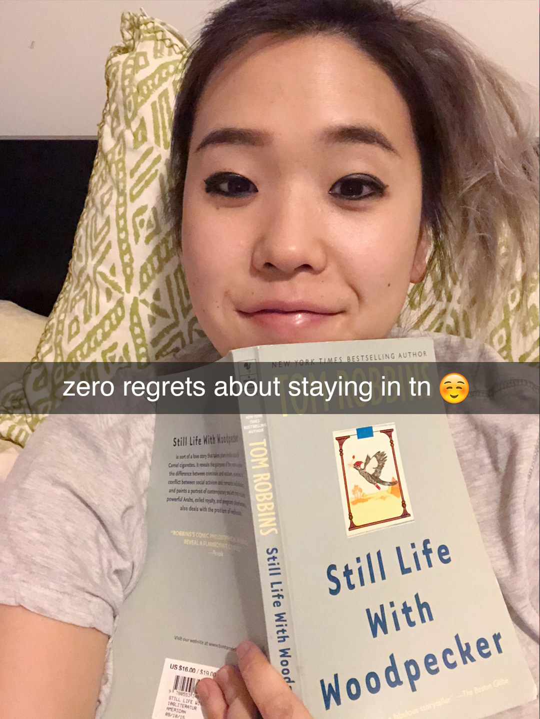 Michelle lays in bed, holding a book with the caption, &quot;Zero regrets about staying in tonight.&quot;