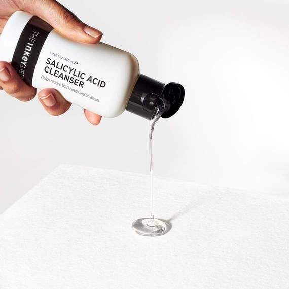 A model pouring out some of the clear cleanser
