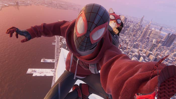 Spider-Man takes a selfie with a cat dressed like him on his back on a rooftop with the skyline of NYC behind him