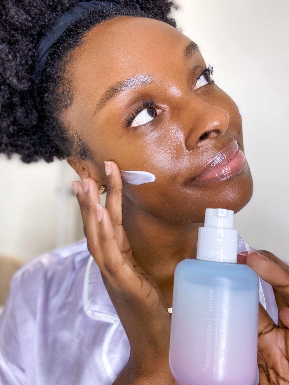 Essence poses with hydrated skin and a swatch of moisturizer.