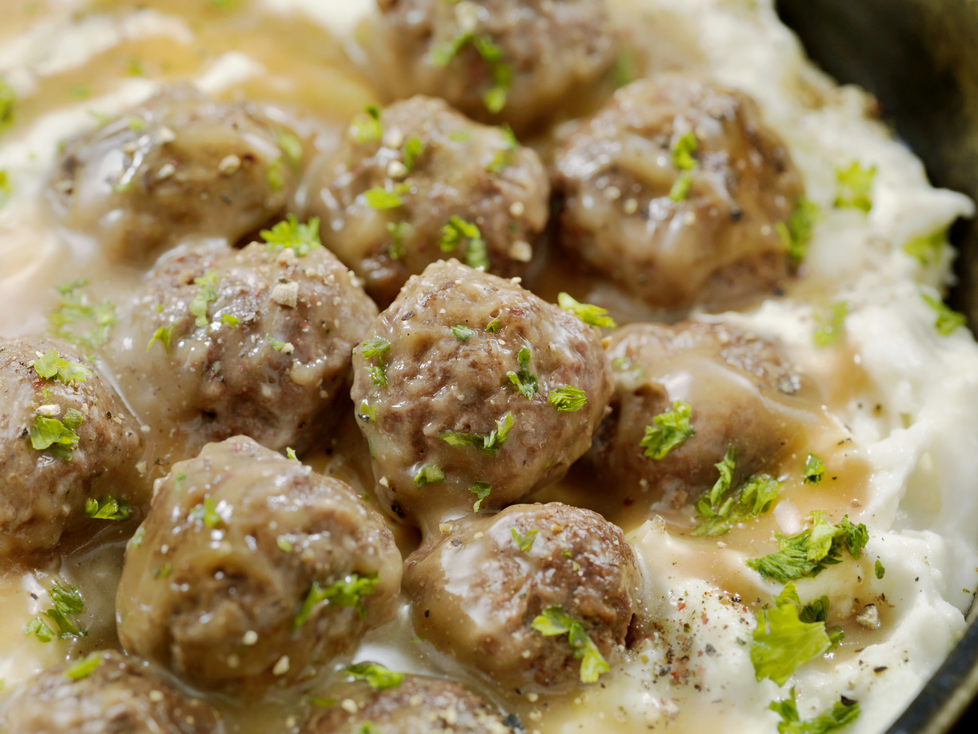 Meatballs in gravy over mashed potatoes.