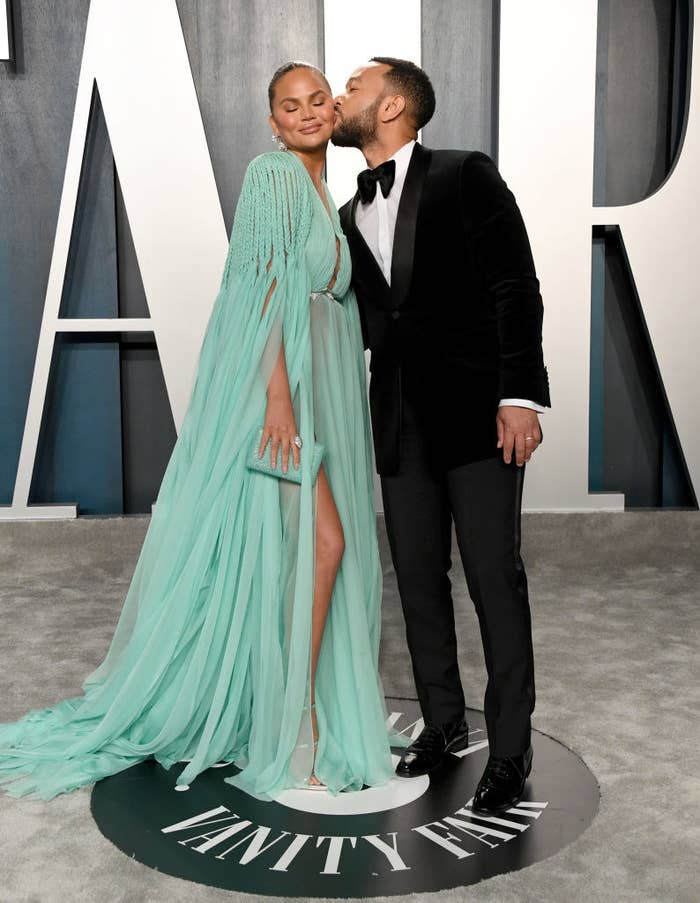 John Legend kissing Chrissy Teigen on the cheek at the 2020 Vanity Fair Oscar Party