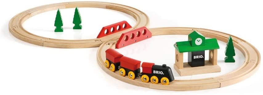 A wooden train set with a track, train, station, and trees