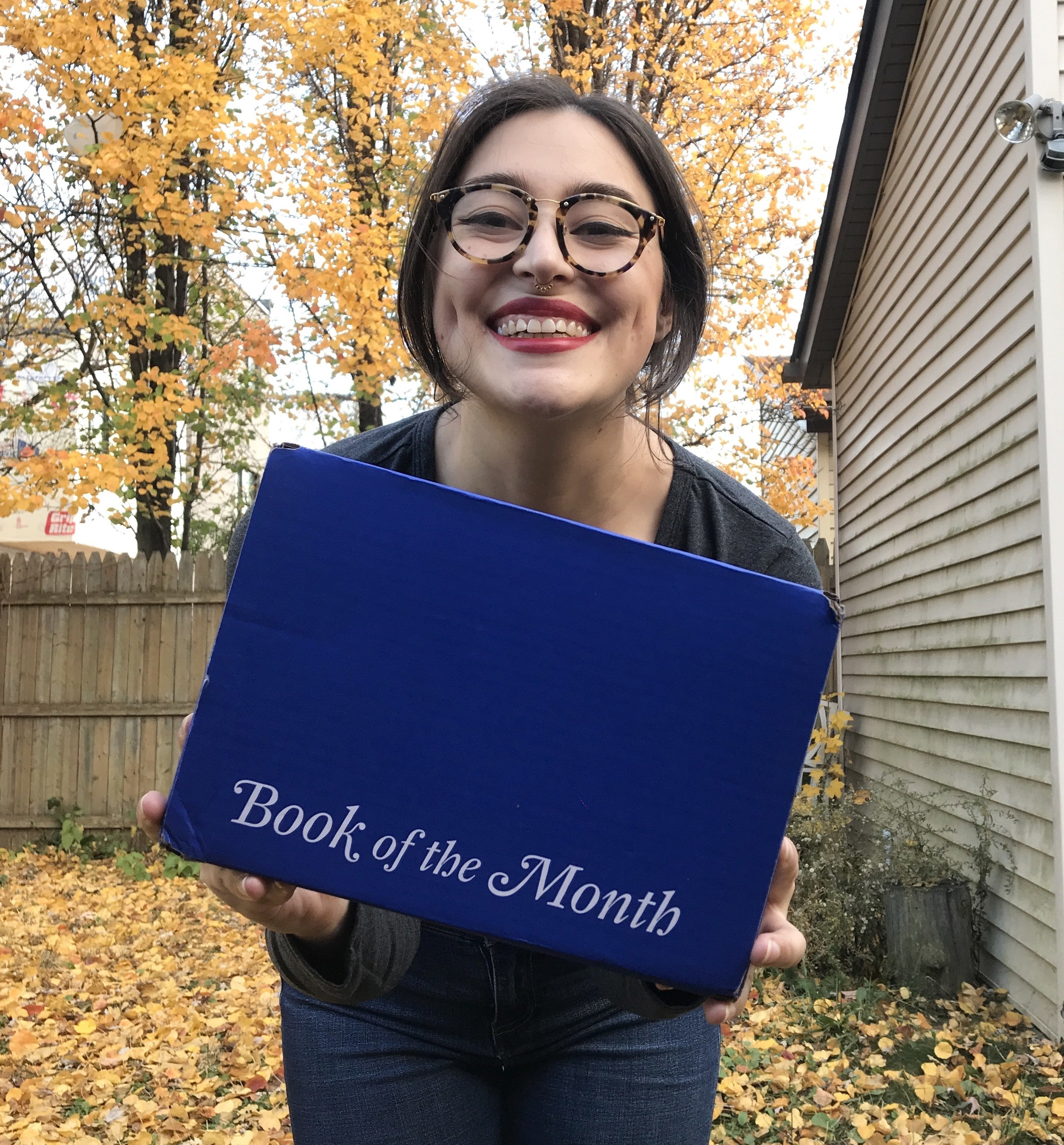 writer holding book of the month box smiling