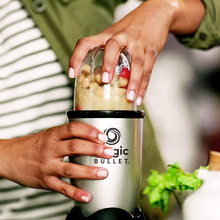 Hands holding a Magic Bullet as it blends
