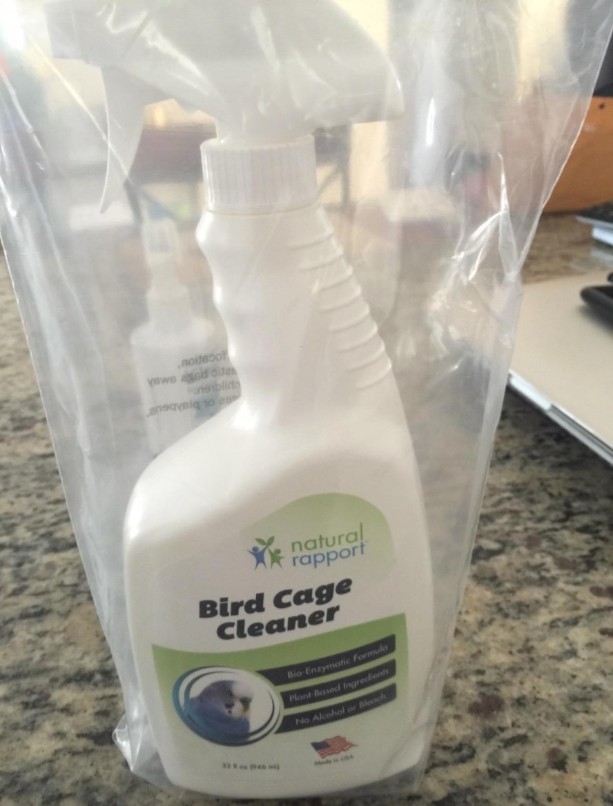 The bird cage cleaner in a white spray bottle