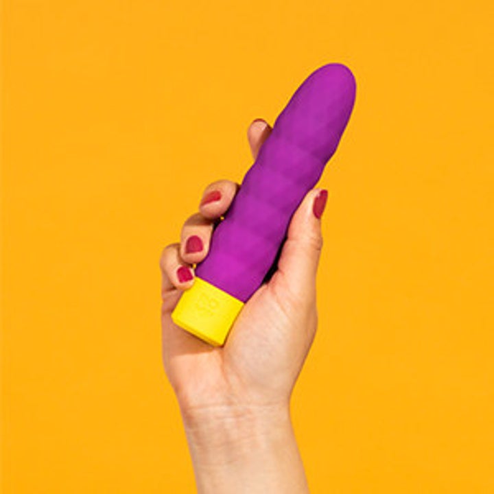 a model's hand holds up the ROMP beat bullet vibrator