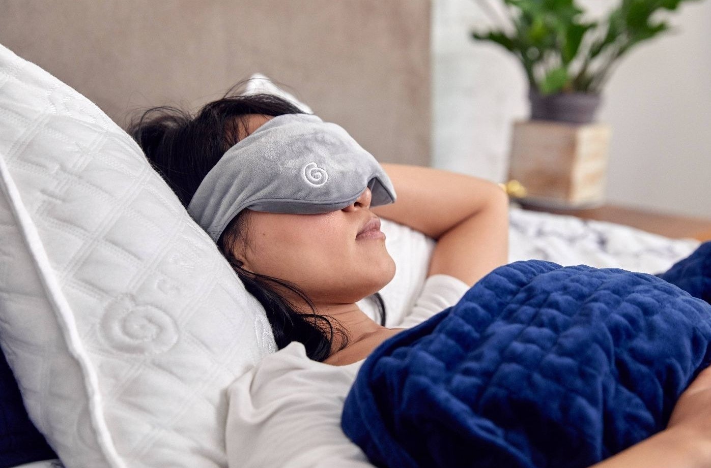 person wearing a gray weighted sleeping mask