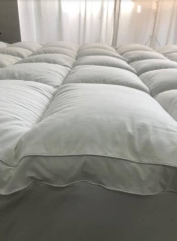 A reviewer's photo which shows the loft of the mattress topper