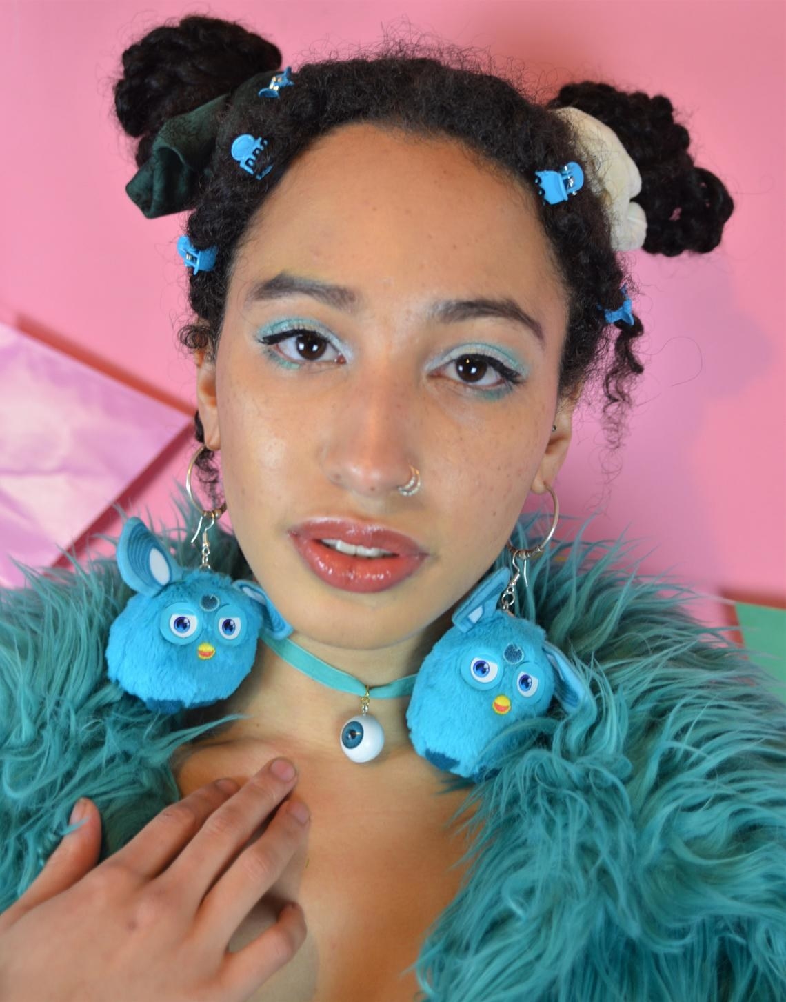 model wears large blue plush furby earrings 