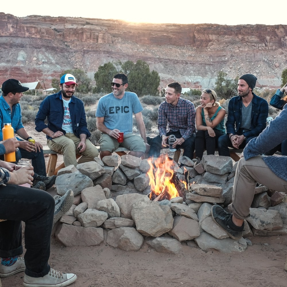 Group of people sitting around a camp fire