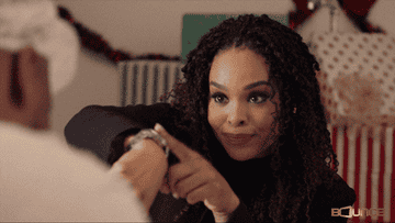 Demetria McKinney in A Stone Cold Christmas aggressively tapping her wristwatch